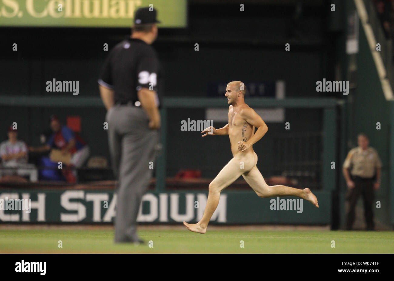 A streaker runs on the field past umpire Sam Holbrook during the