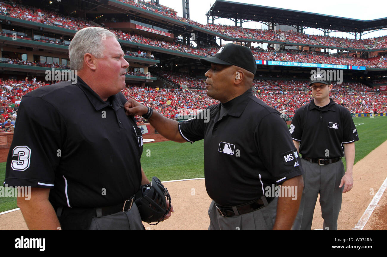 Umpires Laz Diaz and Mike Estabrook (L) comment to St. Louis