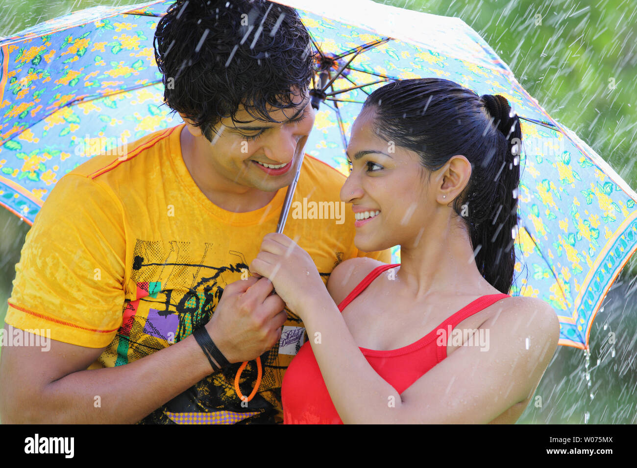 Indian couple under an umbrella in the rain Stock Photo - Alamy