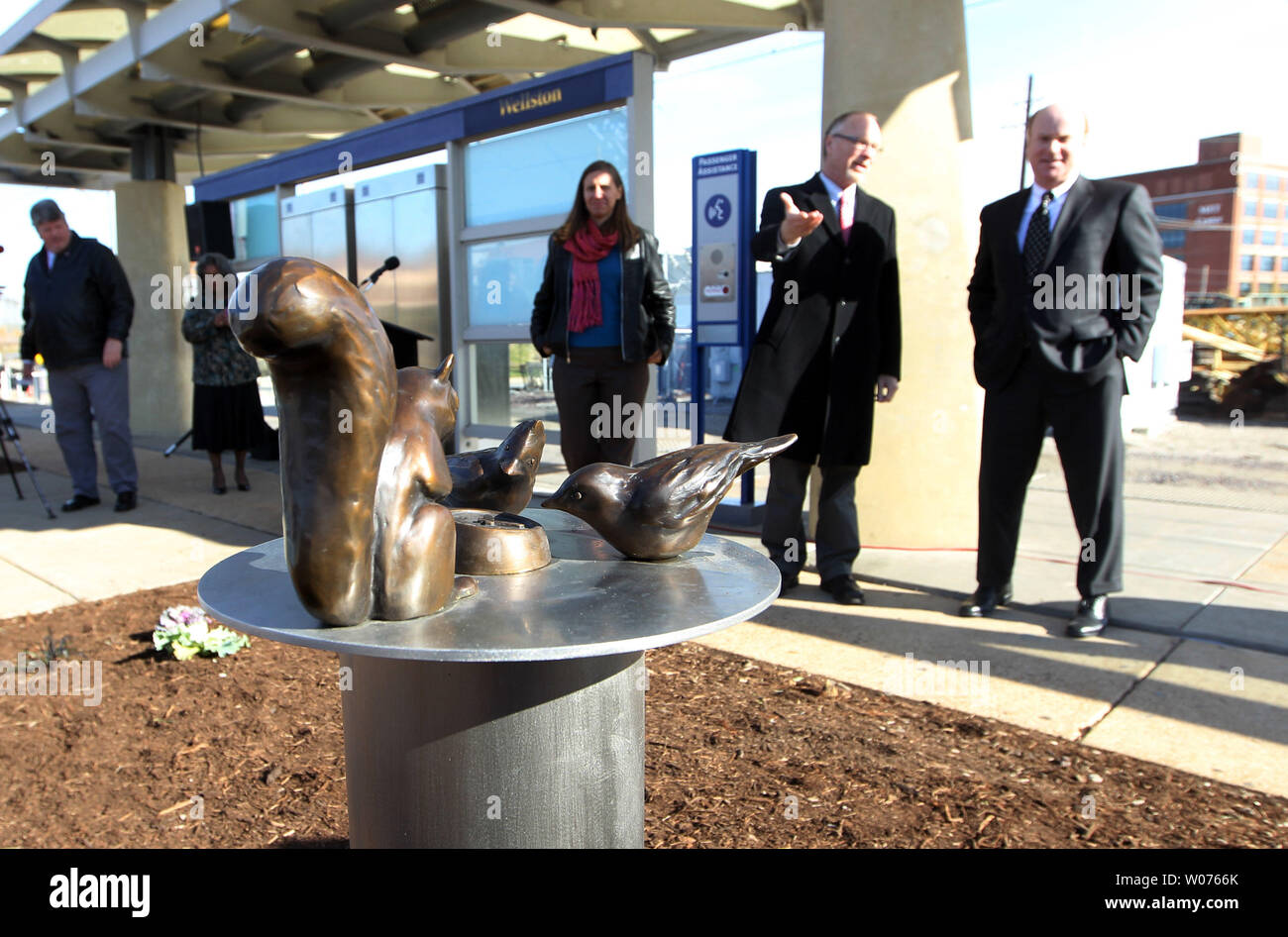 Visitors at the Wellston Metro transit stop get a closer look at the new work of artist Mary Lucking titled 'Everyone Appreciates a Punctual Train,' in Wellston, Missouri on November 14, 2012. The sculpture depict birds and a squirrel staring intently at a bronze clock and was paid for with Federal Transit Administration grants where 80 percent is funded with federal money and 20 percent with local funds. Eventually 10 art projects will be created and installed across the Metro system in the St. Louis area.  UPI/Bill Greenblatt Stock Photo