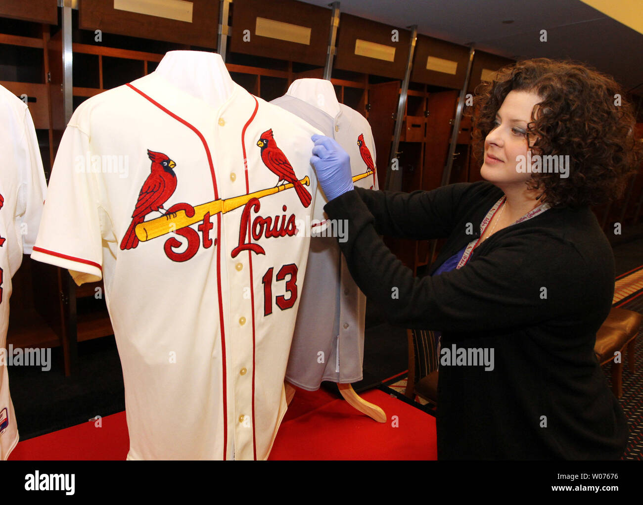 St. Louis Cardinals assistant curator Amy Berra, adjusts the new home  uniform jersey before a press conference at Busch Stadium in St. Louis on  November 16, 2012. For the first time in