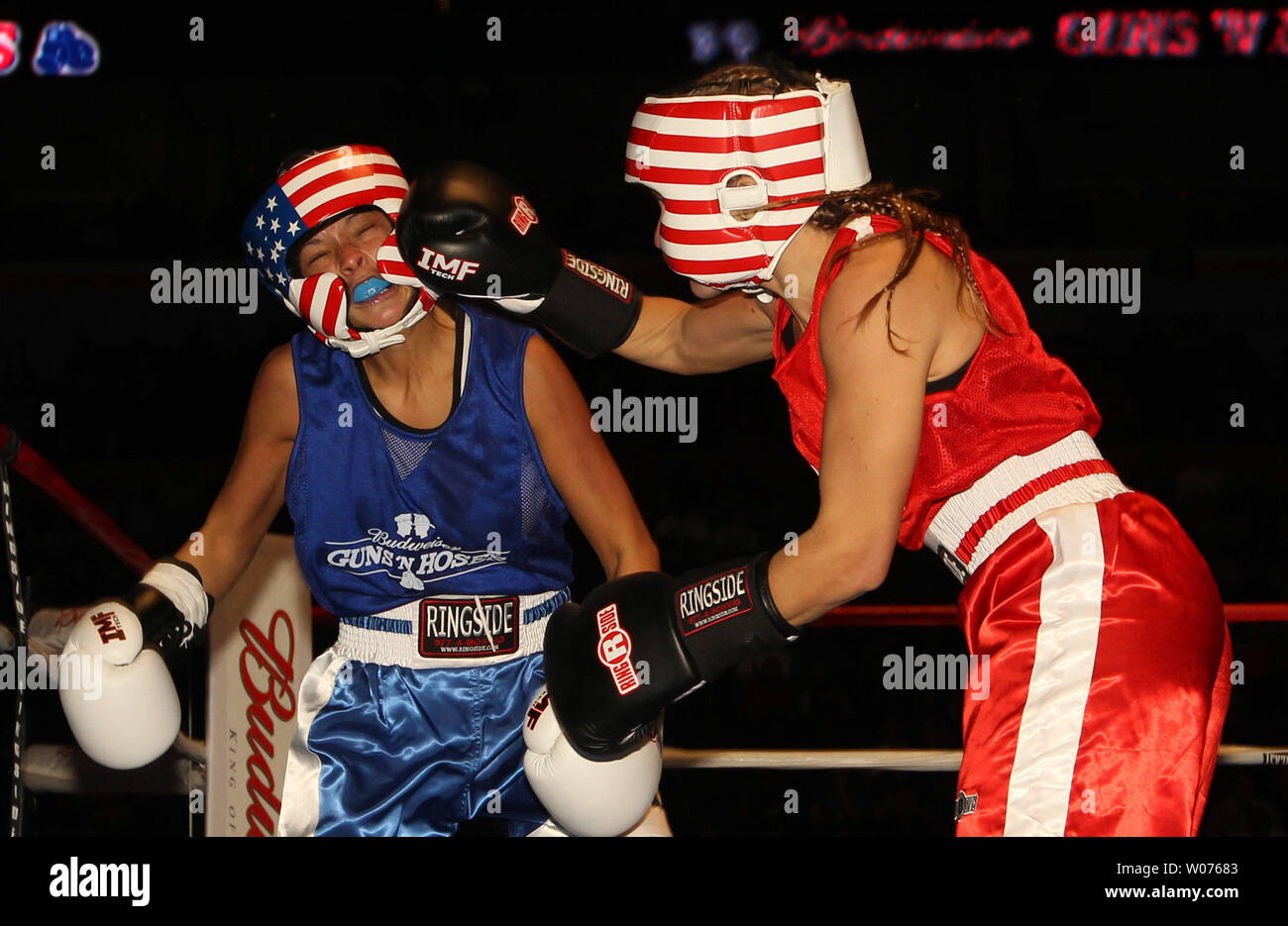 Kelly Kennon of the Union Fire Department connects to the face of Julie Reynolds of the St. Louis Police Department in the first round of the Guns and Hoses Boxing Showdown in St. Louis on November 21, 2012. The annual event in its 26th year, benefit the familys of police, firefighters and EMS personel that have been killed in the line of duty.   UPI/Bill Greenblatt Stock Photo