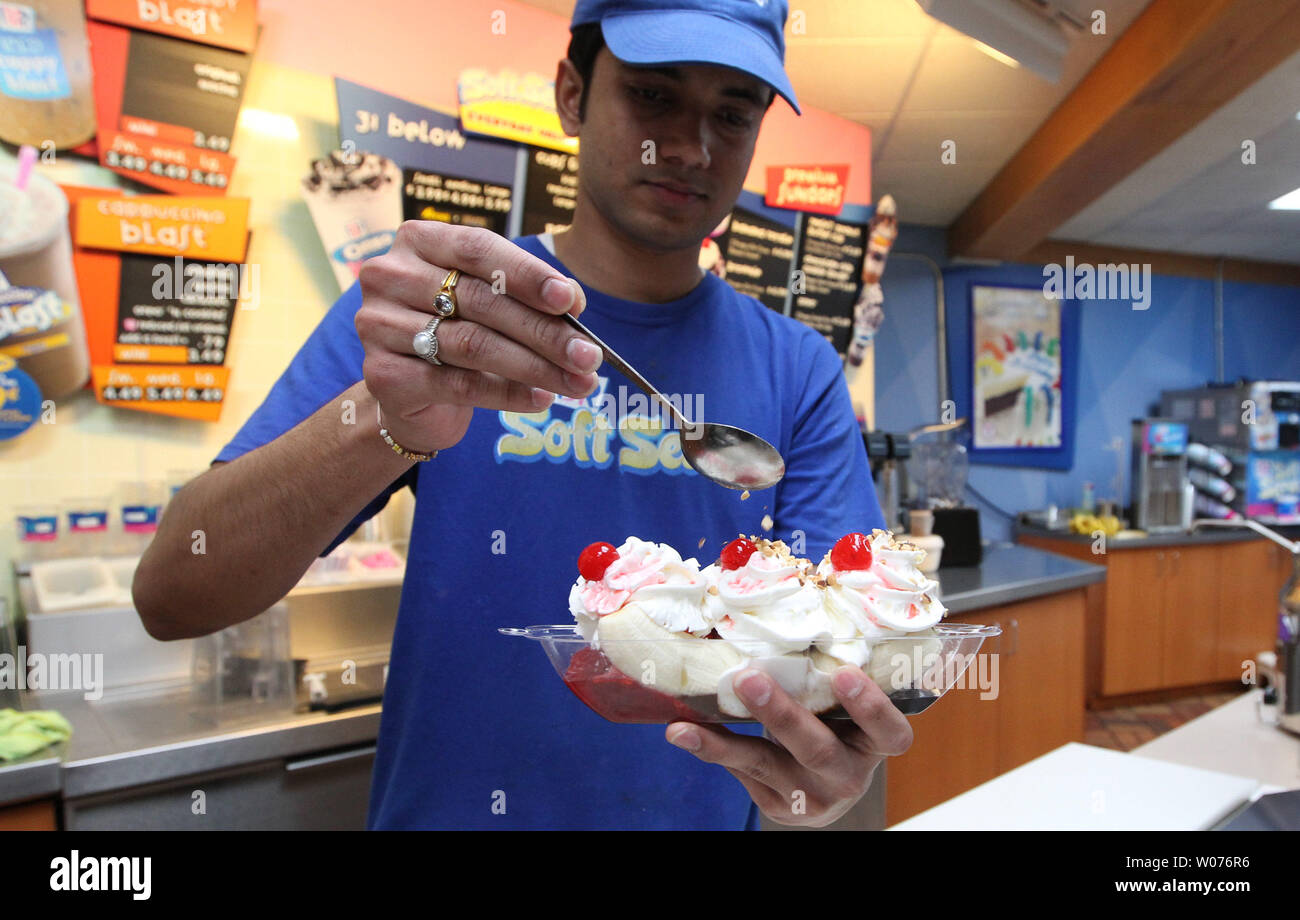 Saumin Patel applies nuts on top of whip cream as he prepares a bananna split on National Whipped Cream Day at Baskin Robbins in Ladue, Missouri on January 5, 2013. National Whipped Cream Day is celebrated on the birthday of Reddi-wip founder and creator Aaron 'Bunny' Lapin.  Lapin did not invent whipped cream, but he was the first person to put whipped cream in an aerosol spray.  UPI/Bill Greenblatt Stock Photo