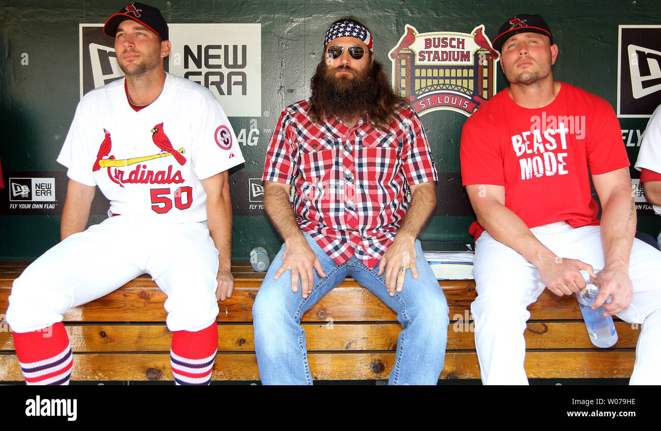 A & E Television's Duck Dynasty star Willie Robertson (C) sits with St. Louis Cardinals Adam Wainwright (L) and Matt Holliday in the dugout during the start of Christian Day at the Ballpark in St. Louis on July 7, 2013.   UPI/Bill Greenblatt Stock Photo