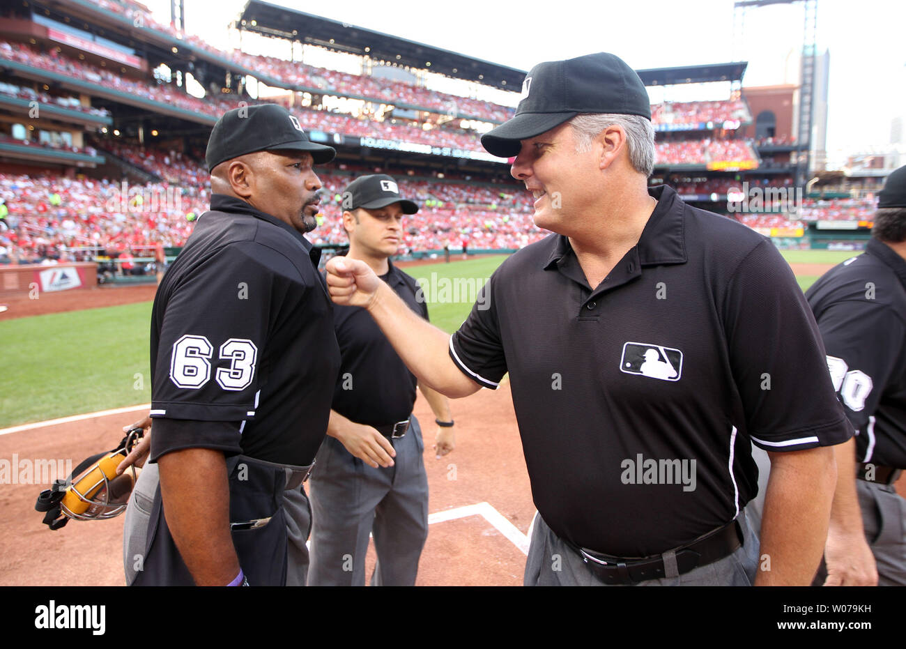 Umpire Tim Timmons gives home plate umpire Laz Diaz a good luck punch