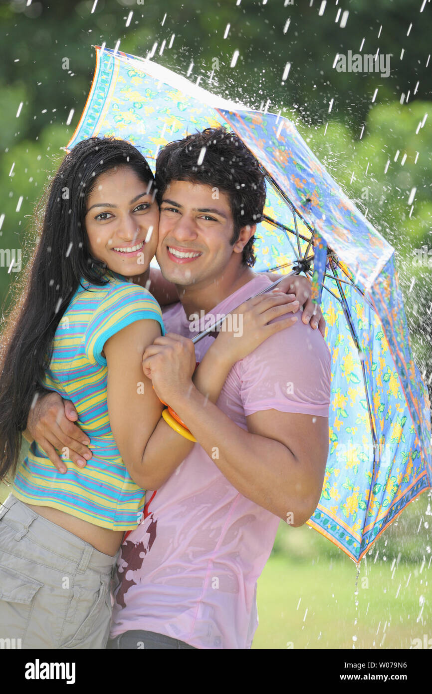 Smiling couple hugging under umbrella hi-res stock photography and images -  Page 2 - Alamy