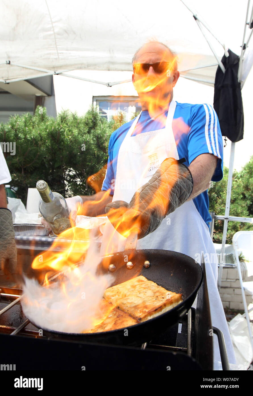 Tom Ginos creates a flame over the fried cheese as he cooks at the Greek Festival in St. Louis on September 2, 103. The annual festival drew record numbers for a single day due to the cooler weather. UPI/Bill Greenblatt Stock Photo