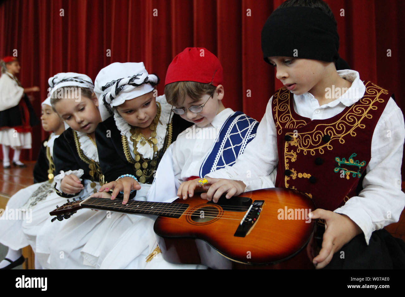 Children in traditional clothing play with a guitar before their turn to dance at the Greek Festival in St. Louis on September 2, 103. The annual festival drew record numbers for a single day due to the cooler weather. UPI/Bill Greenblatt Stock Photo
