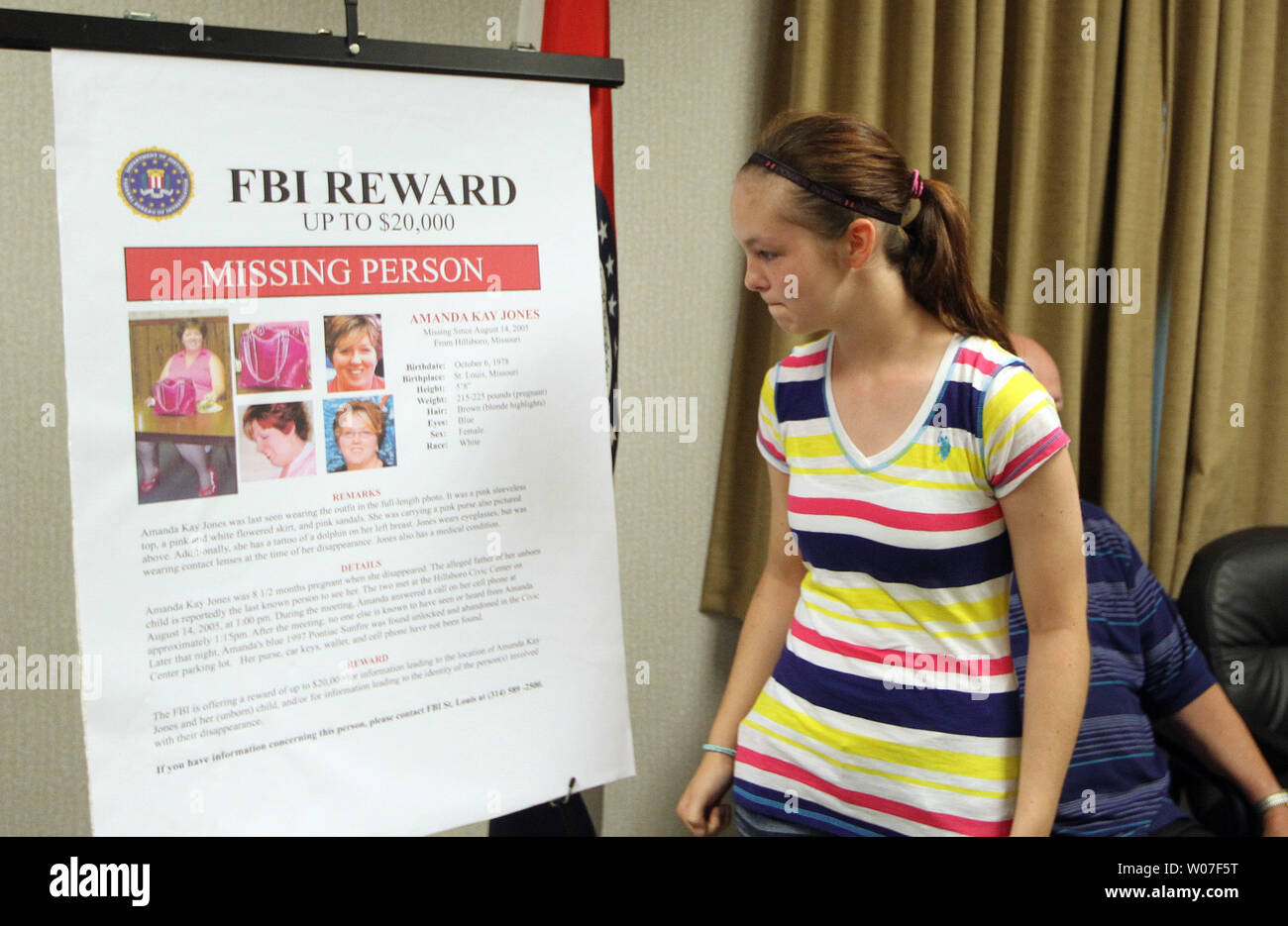Hannah Jones (13) walks past a enlarged missing person poster of her mother Amanda Jones, following a press conference at the St. Louis headquarters of the Federal Beureau of Investigation in St. Louis on August 5, 2014. Amanda Jones went missing, 8 1/2 months pregnant from Hillsboro, Missouri on August 14, 2005 and the FBI, offering a $20,000 reward, belives it has new leads in the case.  UPI/Bill Greenblatt Stock Photo