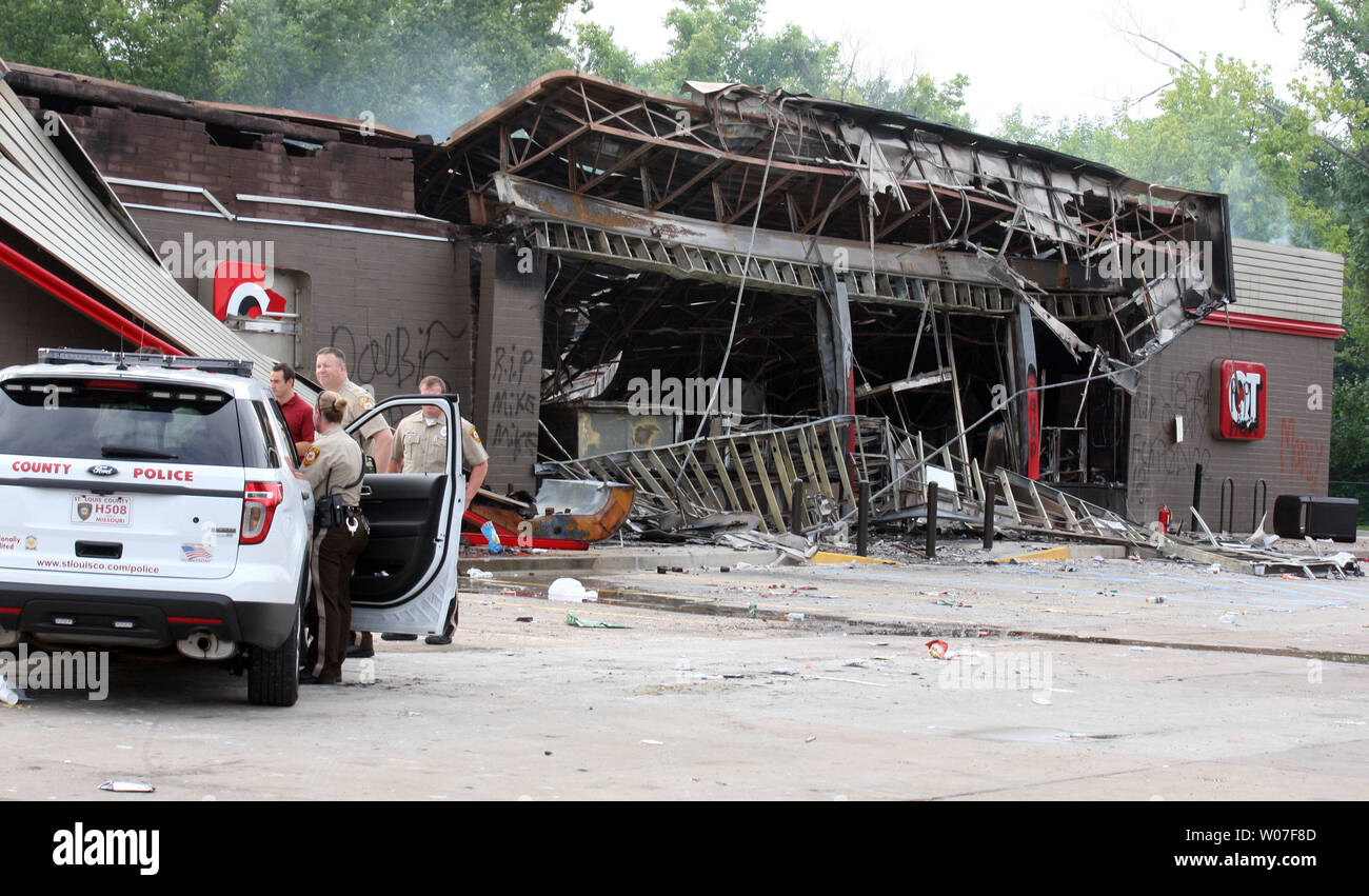 St. Louis County Police stand guard at a QuikTrip Gas station following a night of looting, rioting and arsons in Ferguson, Missouri on August 11, 2014. People are upset because of the Ferguson Police shooting and death of an unarmed black teenager Michael Brown on August 9, 2014. In all about 20 businesses sustained damage after a candlelight vigil turned violent. UPI/Bill Greenblatt Stock Photo