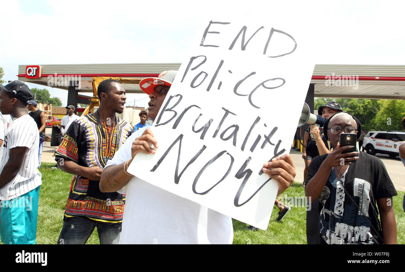 Demonstrators chant on the grounds of a burnt out QuikTrip Gas station following a night of looting, rioting and arsons in Ferguson, Missouri on August 11, 2014. People are upset because of the Ferguson Police shooting and death of an unarmed black teenager Michael Brown on August 9, 2014. In all about 20 businesses sustained damage after a candlelight vigil turned violent. UPI/Bill Greenblatt Stock Photo