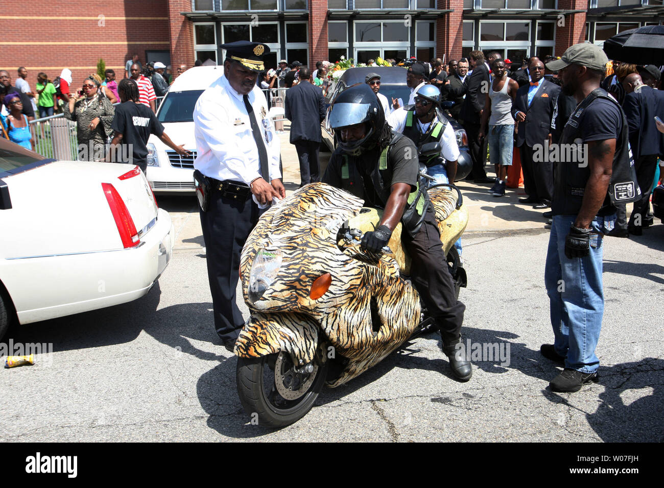 St. Louis Police Col. Reggie Harris looks at a motorcycle that is covered in a tiger skin as he leads the family procession from the Friendly Temple Missionary Baptist Church at the completion of the funeral for Michael Brown Jr. in St. Louis on August 25, 2014. Brown gained attention after was shot by a white Ferguson, Missouri police officer on August 9 and was unarmed. The shooting led to several nights of looting, arrests and heavy police presence.   UPI/Bill Greenblatt Stock Photo