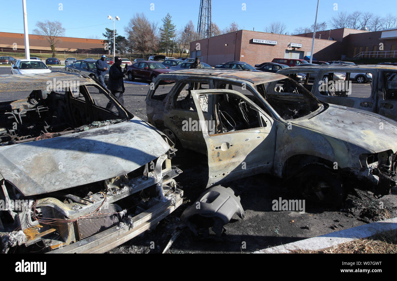 Sight seeers walk past shells of burned out cars at a dealership in Ferguson, Missouri on November 25, 2014. After the verdict was read in the Michael Brown shooting case looting, riots and fires broke out in the Ferguson, Missouri area, prompting the Governor to add additional national guard troops.    UPI/Bill Greenblatt Stock Photo