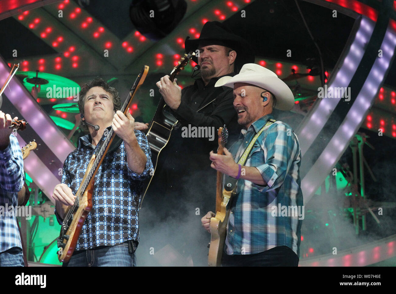Country singer Garth Brooks (C) performs with band members on Opening Night  at the Scottrade Center in St. Louis on December 4, 2014. Brooks will play  four concerts in four nights in