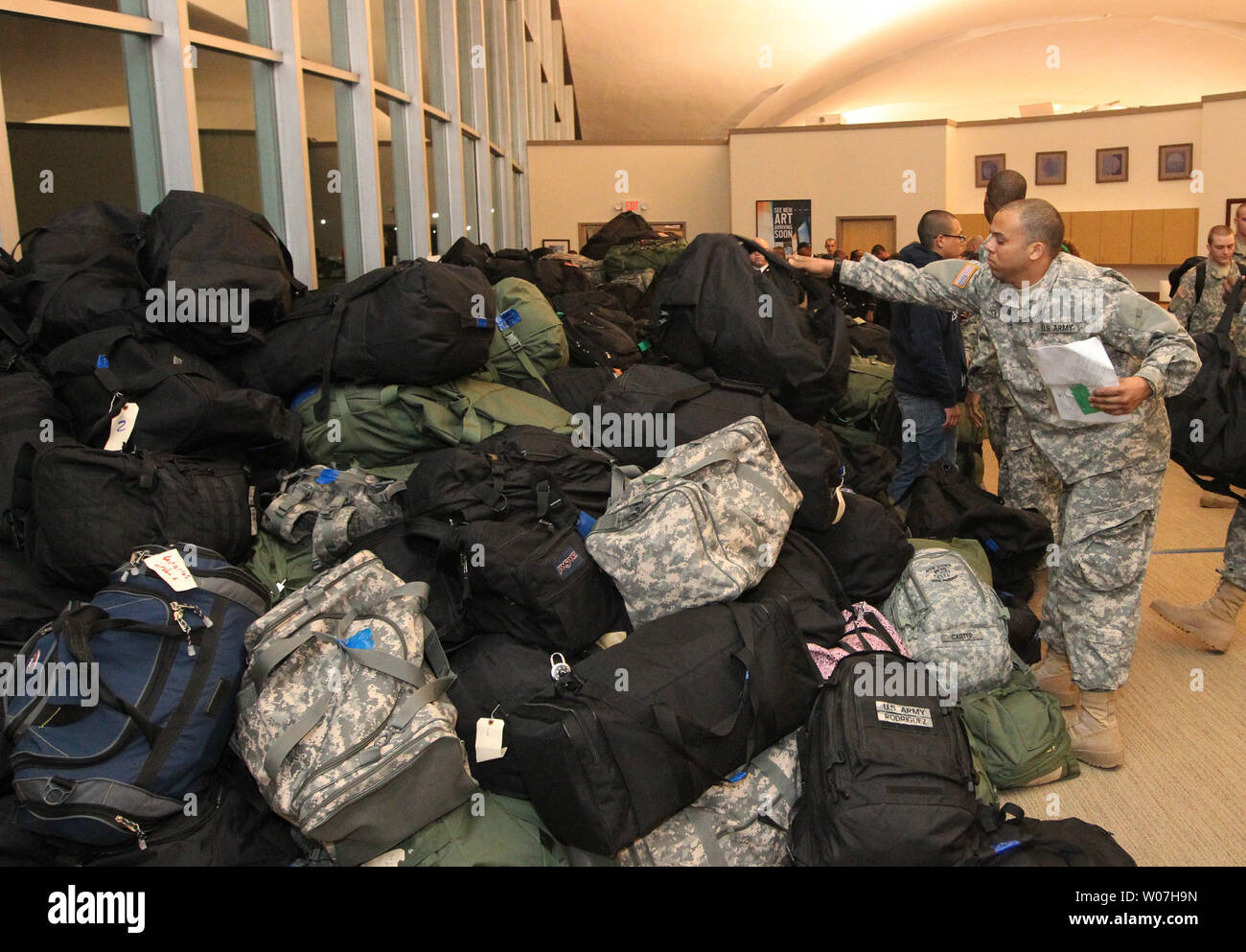 A soldier retrieves his bag from a pile during Holiday Block leave at Lambert-St. Louis International Airport on December 20, 2014. Nearly 5500 soldiers from Fort Leonard Wood converge on the airport at once at they go home for the holidays.   UPI/Bill Greenblatt Stock Photo