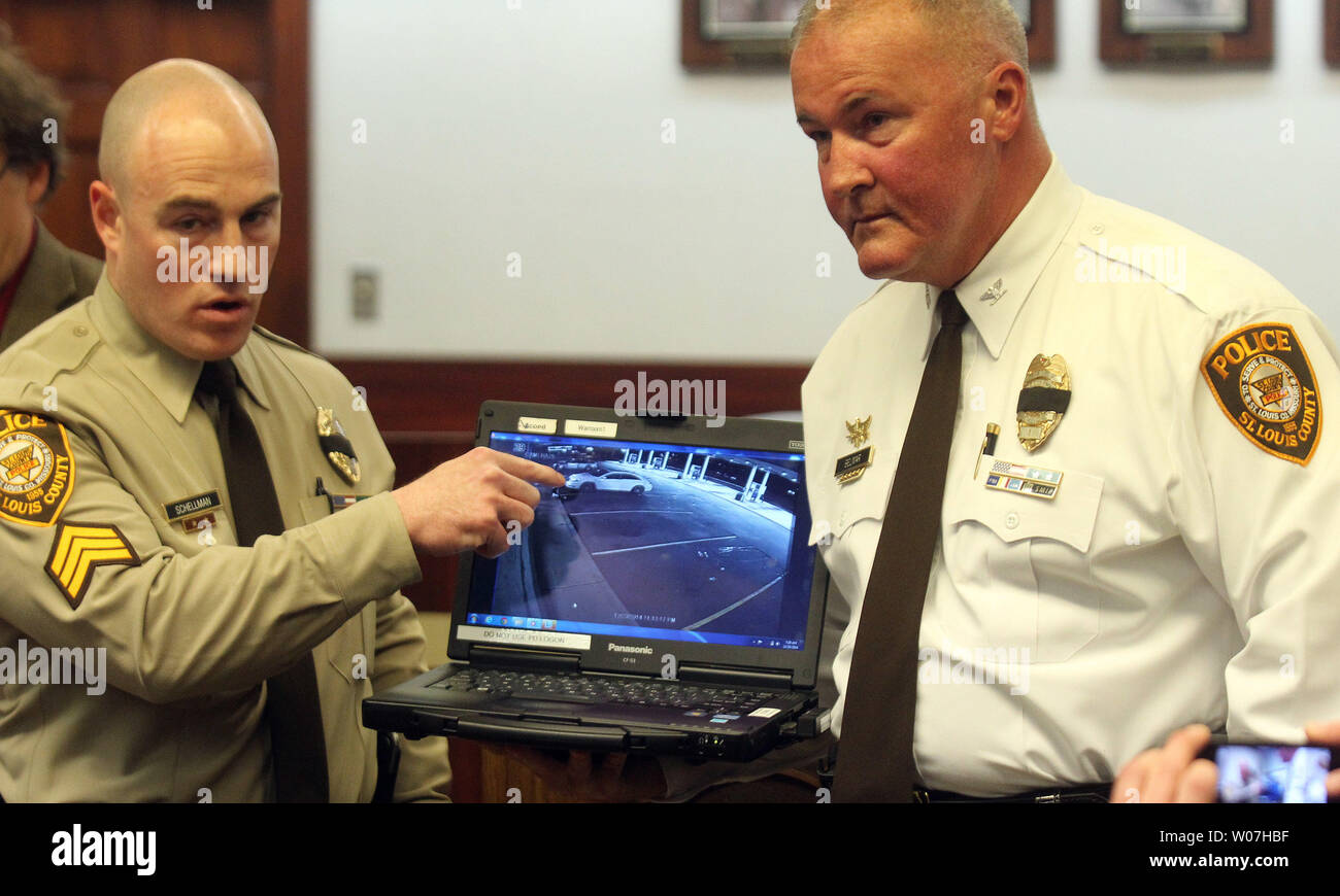 St. Louis County Police Sergeant Brian Schellman (L) points to a man pointing a handgun at a