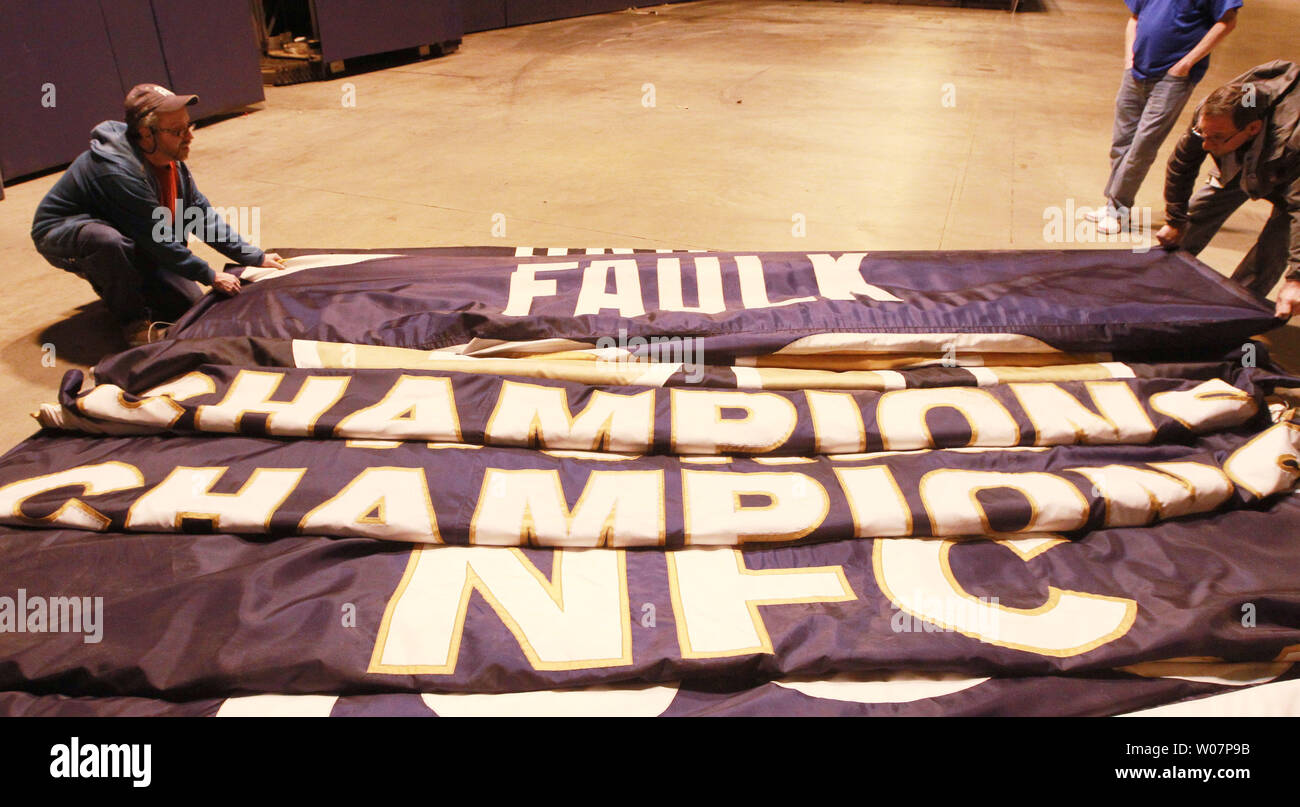 Decoraters fold banners that have been lowered from the rafters of the ...