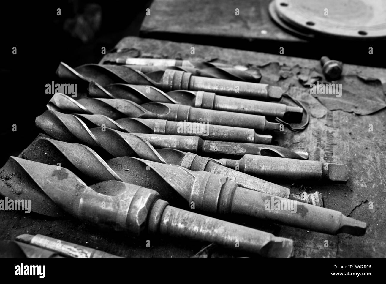 Old drills on machine shop bench Stock Photo