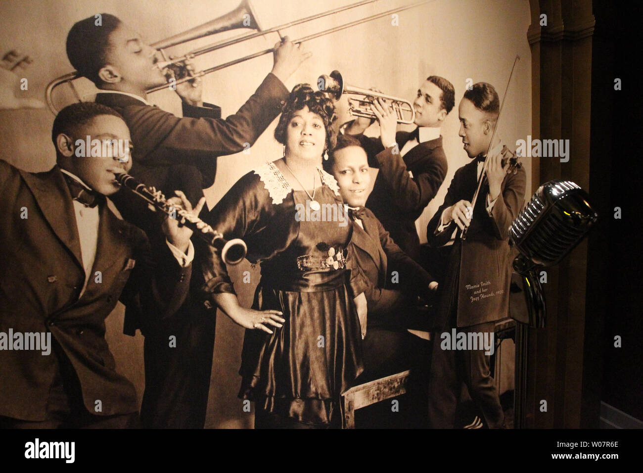 A chrome microphone stands in front of a 1920 photo of Mamie Smith and her Jazz Hounds at the National Blues Museum on the opening day of business in St. Louis on April 2, 2016.   Photo by Bill Greenblatt/UPI Stock Photo