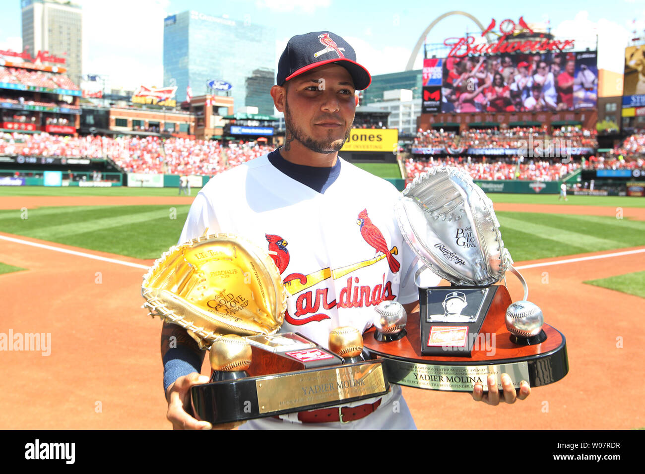 St. Louis Cardinals catcher Yadier Molina walks to the dugout after  accepting his Rawlings Gold Glove and Platinum Glove awards for his  defensive skills during the 2015 season before a game against