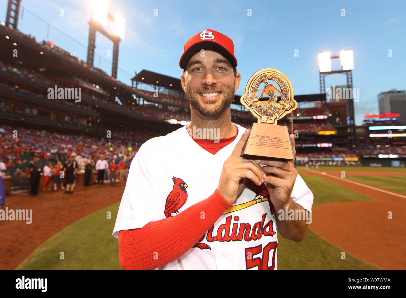 St. Louis Cardinals pitcher Adam Wainwright shows off his trophy after it  is announced that he is the team's 2016 nominee for Roberto Clemente Award,  before a game against the Chicago Cubs