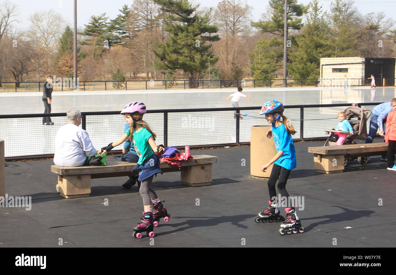 Young Girls Choose To Roller Blade Past The Few Ice Skating At