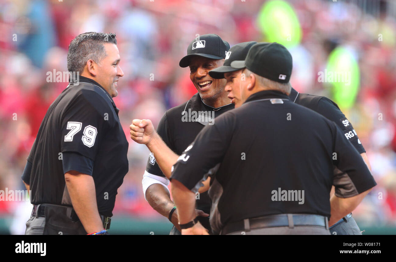 Umpires CB Bucknor, Mark Carlson and Fieldin Culbreth, punch the chest protector of home plate