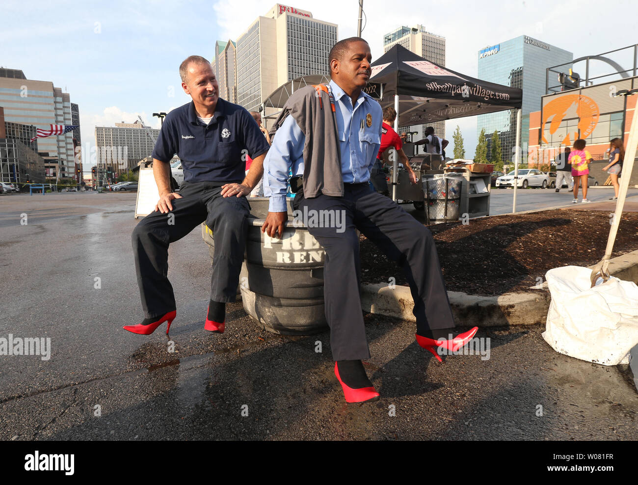 St. Louis firefighter Charlie Poehl (L) and captain Duane Daniels take a break from their high heels before participating in the YWCA's Walk a Mile in Their Shoes in St. Louis on August 3, 2017. In it's fifth year, men walk several blocks in women's high heels to bring attention to domestic violence and several other women's issues.   Photo by Bill Greenblatt/UPI Stock Photo