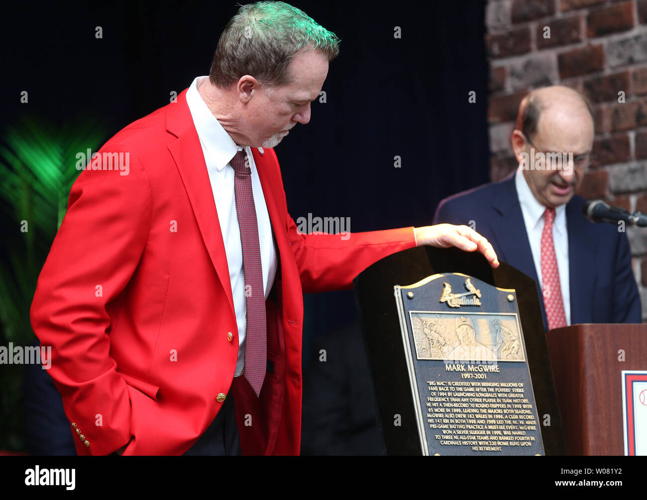 Newly inducted St. Louis Cardinals Hall of Fame member Mark McGwire looks at his placque as Cardinals Chairman Bill DeWitt Jr.reads an introduction during the St. Louis Cardinals Hall of Fame Induction ceremonies in St. Louis on August 26, 2017. McGwire played 4 1/2 years with the Cardinals breaking Roger Maris' home run record, hitting 70 home runs in 1998 and is now the bench coach for the San Diego Padres.       Photo by Bill Greenblatt/UPI Stock Photo