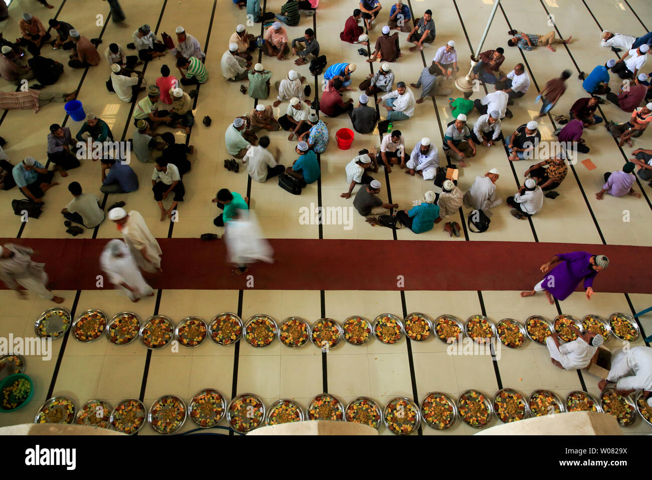 Devotees at a mass-iftar gathering at Baitul Mukarram National Mosque during the month of Ramadan. Dhaka, Bangladesh. Stock Photo