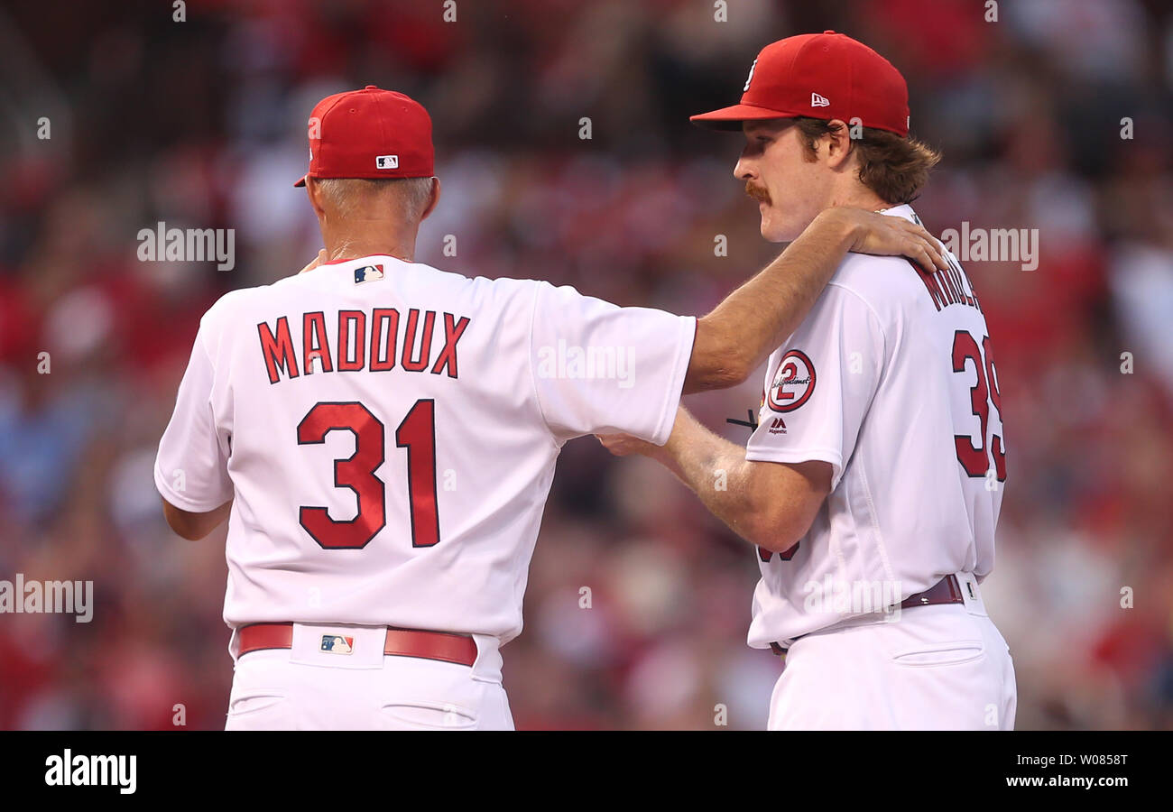 St. Louis Cardinals pitching coach Mike Maddux places his hand on the