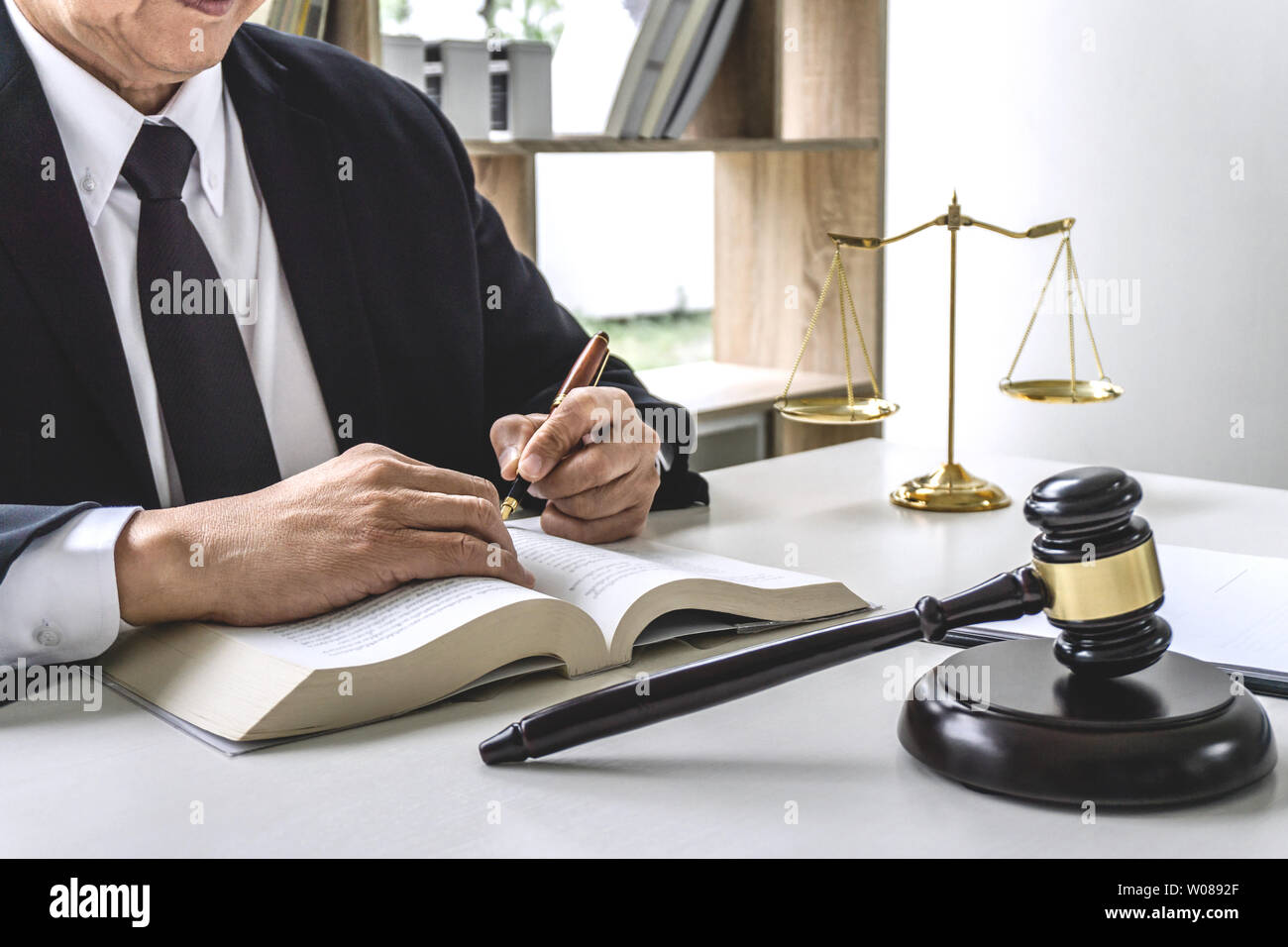 Law, lawyer attorney and justice concept, male lawyer or notary working on a documents and report of the important case in the workplace office. Stock Photo