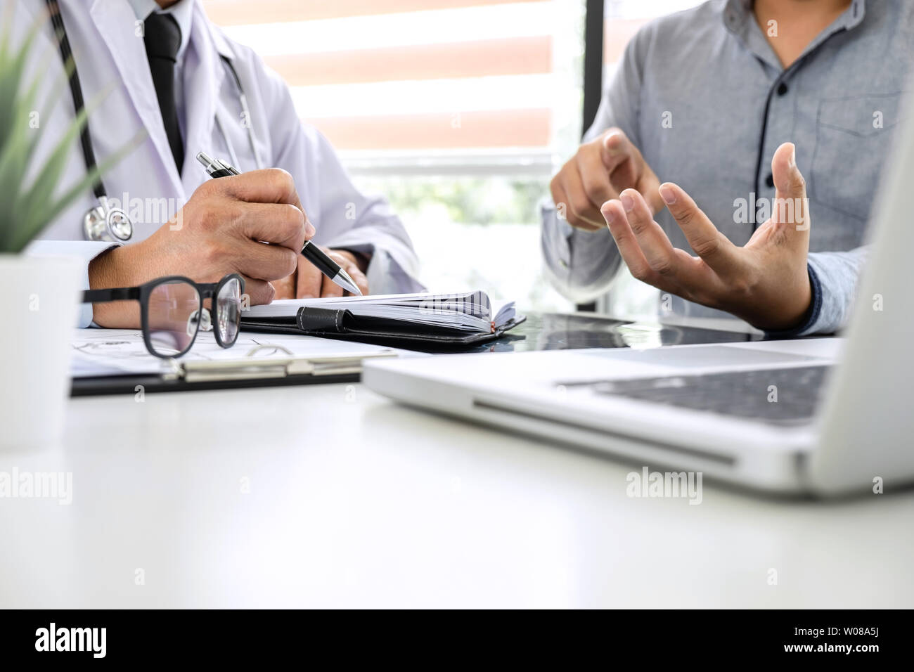 Professor Doctor recommend treatment method with patient and holding x-ray film while discussing explaining symptoms or counsel diagnosis health, heal Stock Photo