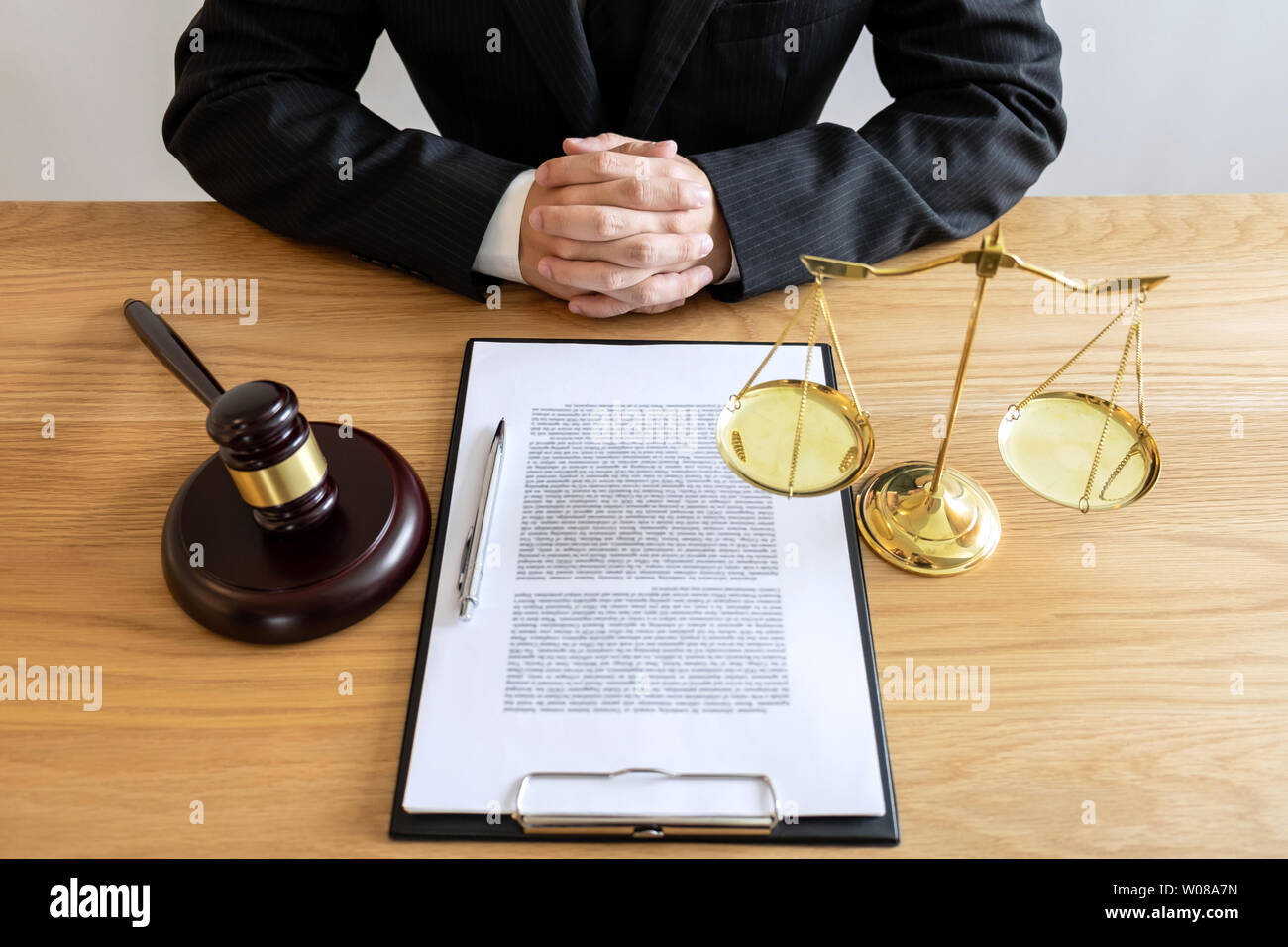 Legal law, advice and justice concept, male lawyer or notary working on a documents and report of the important case and wooden gavel, balance on tabl Stock Photo