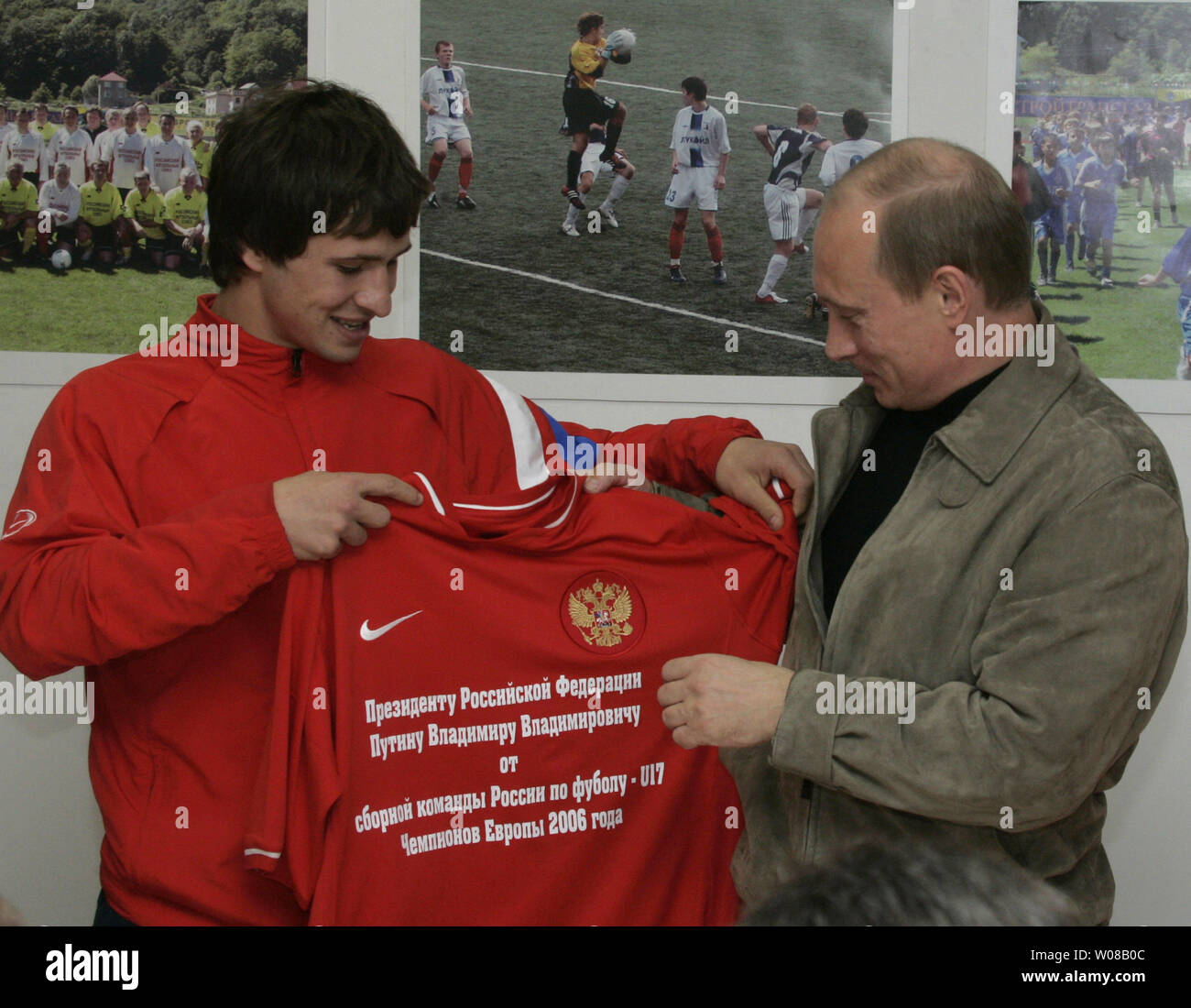 Russian President Vladimir Putin (R) gets a gift, T-shirt from the youth soccer team Sputnik in the Black Sea city of Sochi on May 19, 2006. This team won European championship this May. (UPI Photo/Anatoli Zhdanov) Stock Photo