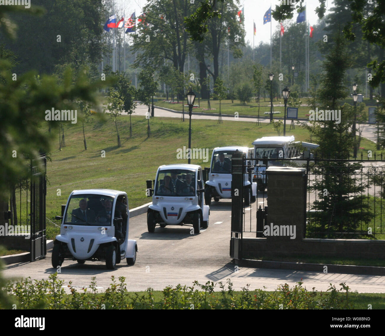 Russian President Vladimir Putin drives an electric car (2nd L) as he arrives with his wife Lyudmila to a dinner with U.S. President George W. Bush at the Italian Guest House in the Konstantinovsky Palace Complex in Strelna, in the outskirts of St. Petersburg on July 14, 2006. Bush is visiting Russia to attend the G8 summit this weekend. (UPI Photo/Anatoli Zhdanov) Stock Photo