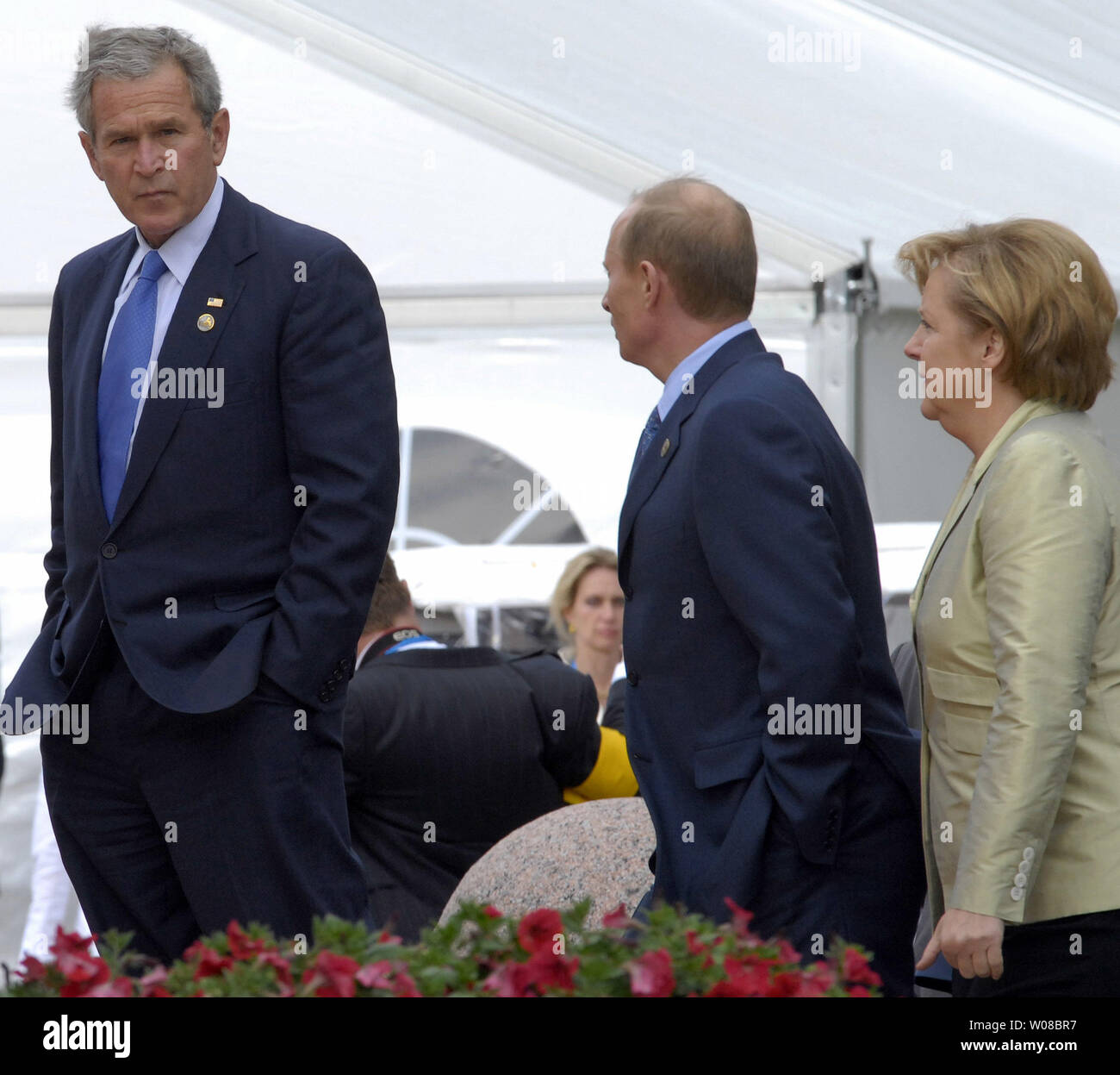 President George W. Bush (L) looks back to President Vladimir Putin and German Chancellor Angela Merkel (R) as they leave after a group photo during the G8 Summit at the Konstantinovsky Palace in Strelna, outside Saint Petersburg, Russia on July 16, 2006. (UPI Photo/Dima Volgin) Stock Photo