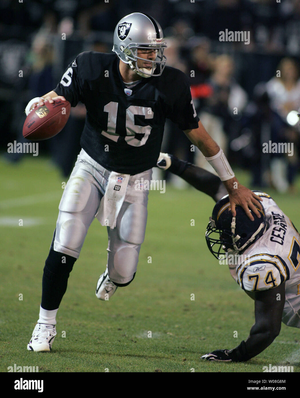 Oakland Raiders QB Andrew Walter (16) scrambles away from San Diego  Chargers Jacques Cesaire (74) at