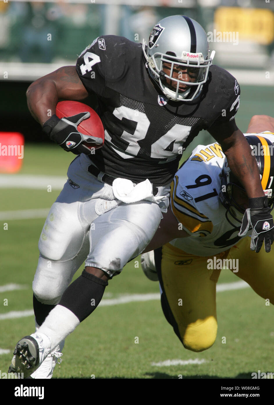 Oakland Raiders LaMont Jordan (34) eludes Pittsburgh Steelers Aaron Smith  (91) for a five yard gain in the second quarter at McAfee Coliseum in  Oakland, California on October 29, 2006. The Raiders