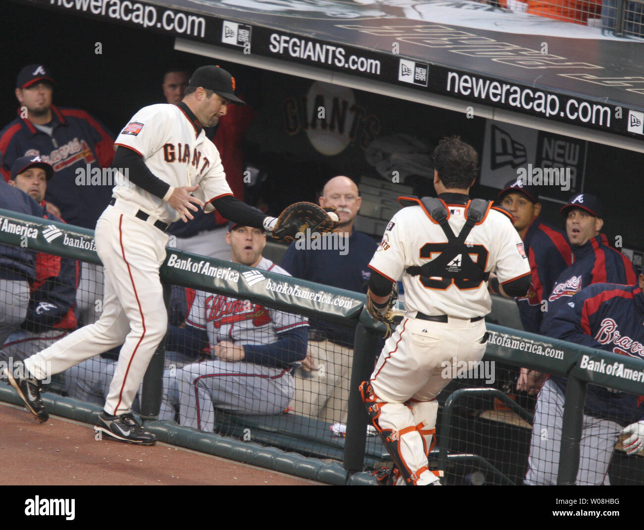 San Francisco Giants first baseman Rich Aurilia  (L) catches a pop foul by Atlanta Braves Yunel Escobar in the Atlanta dugout in the third inning  at AT&T Park in San Francisco on July 25, 2007.  Catcher Guillermo Rodriguez (39) looks on as he Giants defeated the Braves 2-1.  (UPI Photo/Terry Schmitt) Stock Photo