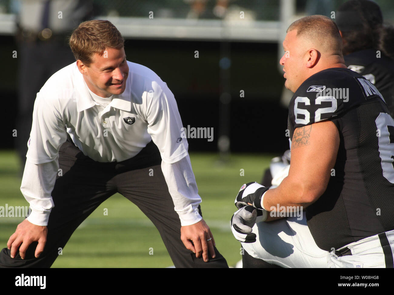Oakland Raiders Head Coach Lane Kiffin (L) chats with center Jeremy Newberry (62)  as they warm up to play the St. Louis Rams at McAfee Coliseum in Oakland, California on August 24, 2007.    (UPI Photo/Terry Schmitt) Stock Photo