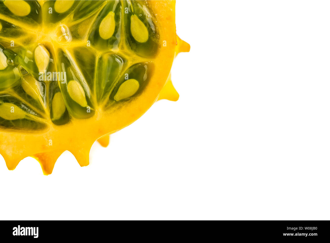 Kiwano or Horned Melon (Cucumis metuliferus) sliced in a half on white
