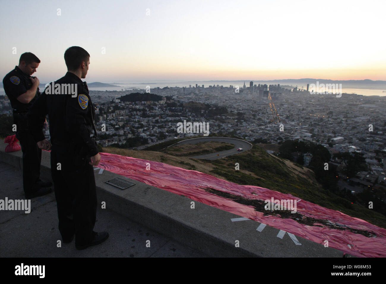 Police officers check out arson vandalism on the huge pink triangle placed on Twin Peaks in San Francisco on June 28, 2009.  The symbol is placed on the city's highest peak for Gay Pride week.   (UPI Photo/Terry Schmitt) Stock Photo