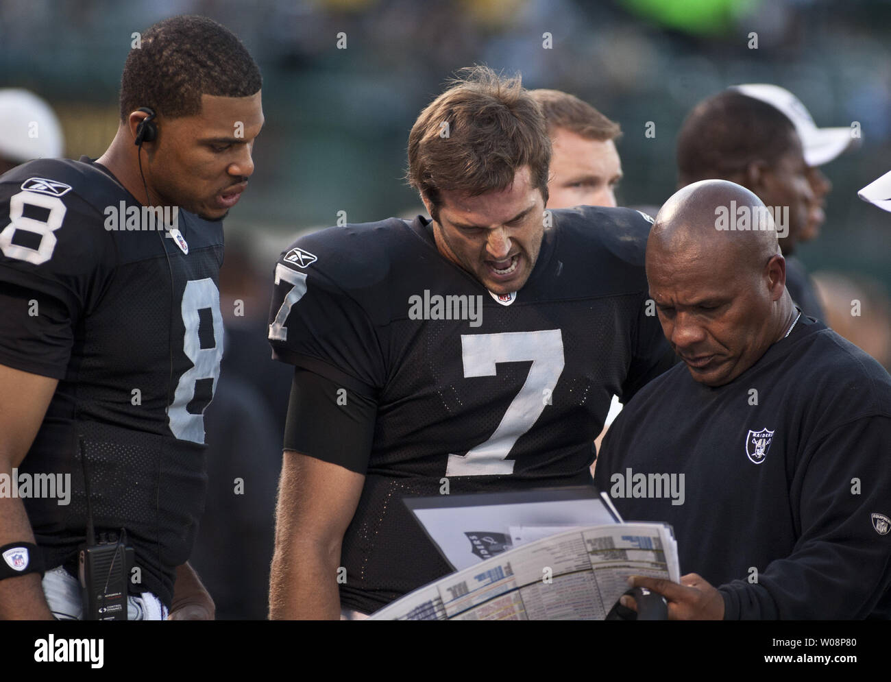 Oakland Raiders Head Coach Hue Jackson (R) goes over the play list with quarterbacks Jason Campbell (8) and Kyle Boller (7) on the  sidelines  against the New Orleans Saints at the Coliseum in Oakland, California on August 28, 2011.   UPI/Terry Schmitt Stock Photo
