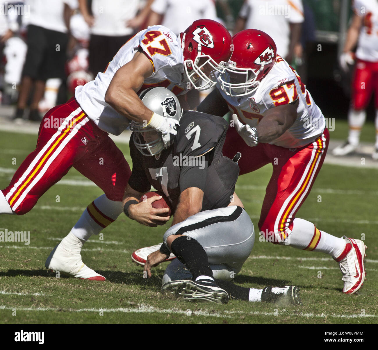 Oakland Raiders QB Kyle Boller (7) is tackled by Kansas City Chiefs Jon McGraw (47) and Allen Bailey (97) at the O.co Coliseum in Oakland, California on October 23, 2011.   UPI/Terry Schmitt Stock Photo
