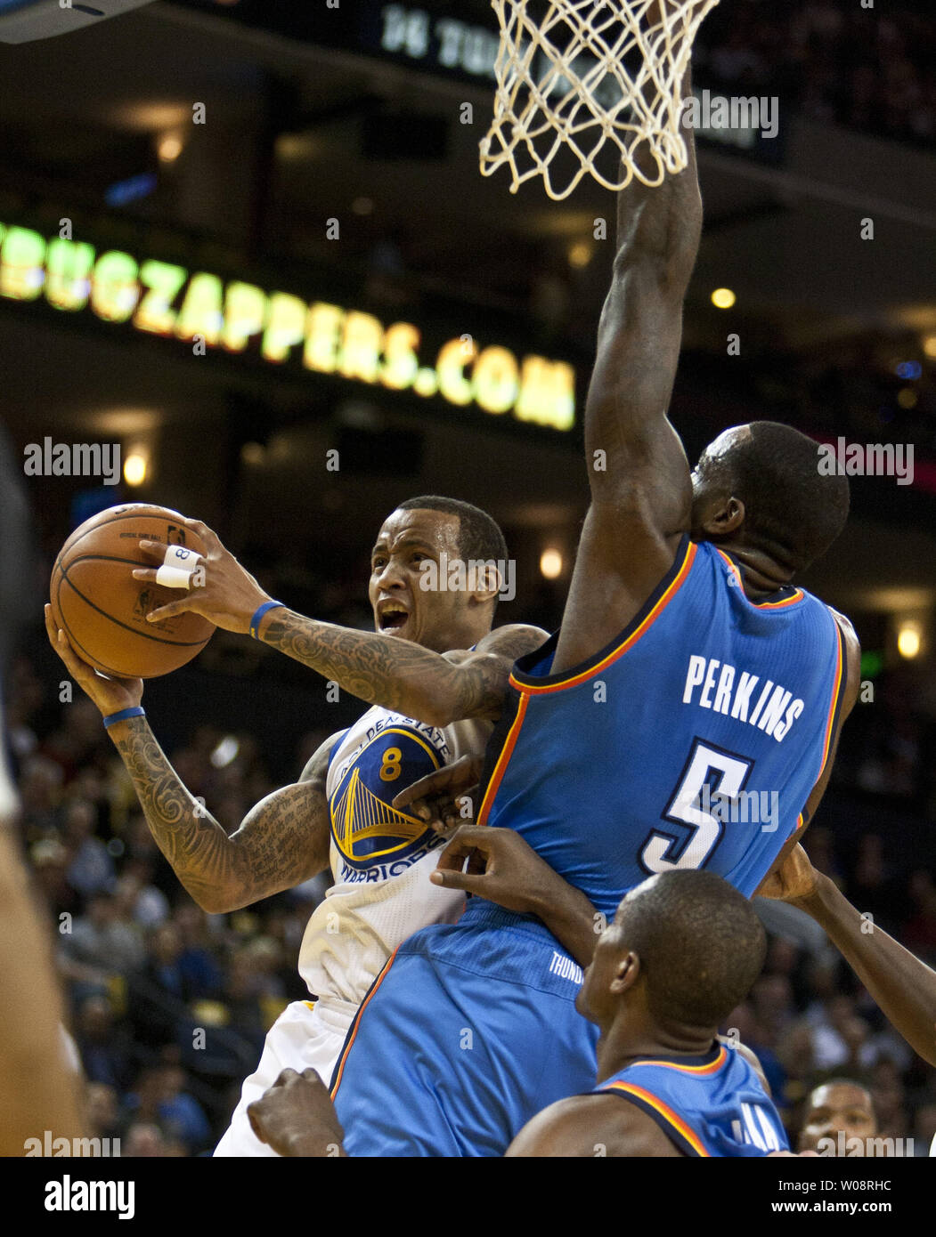 Golden State Warriors Stephen Curry (30) throws up a shot back at the  basket around Oklahoma City Thunder's Kendrick Perkins in the first half at  the Oracle Arena in Oakland, California on