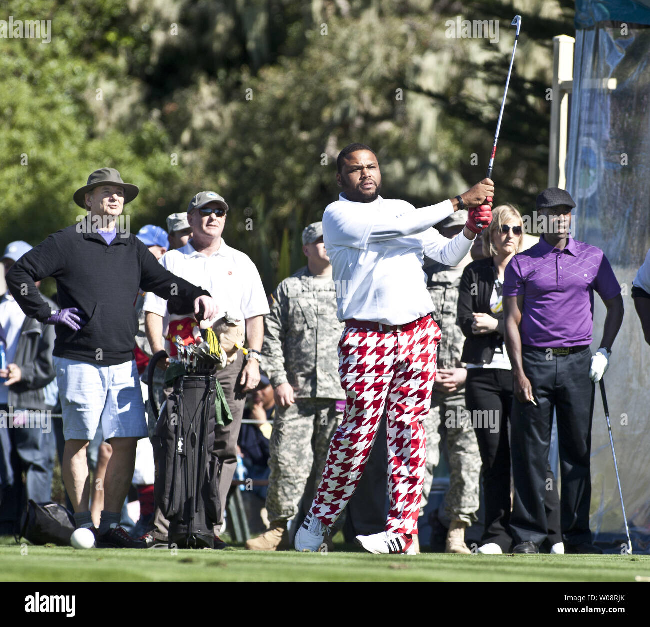 Actor Anthony Anderson tees off on the 17th in the 3M Celebrity Challenge prior to the AT&T Pro-Am at Pebble Beach, California on February 8, 2012.  Bill Murray (L) and Don Cheadle (R) watch. UPI/Terry Schmitt Stock Photo