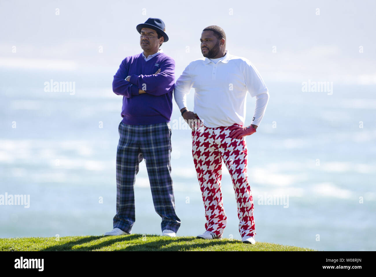 Comedian George Lopez (L) and actor Anthony Anderson stand with their backs to the Pacific Ocean watching the 3M Celebrity Challenge prior to the AT&T Pro-Am at Pebble Beach, California on February 8, 2012.   UPI/Terry Schmitt Stock Photo