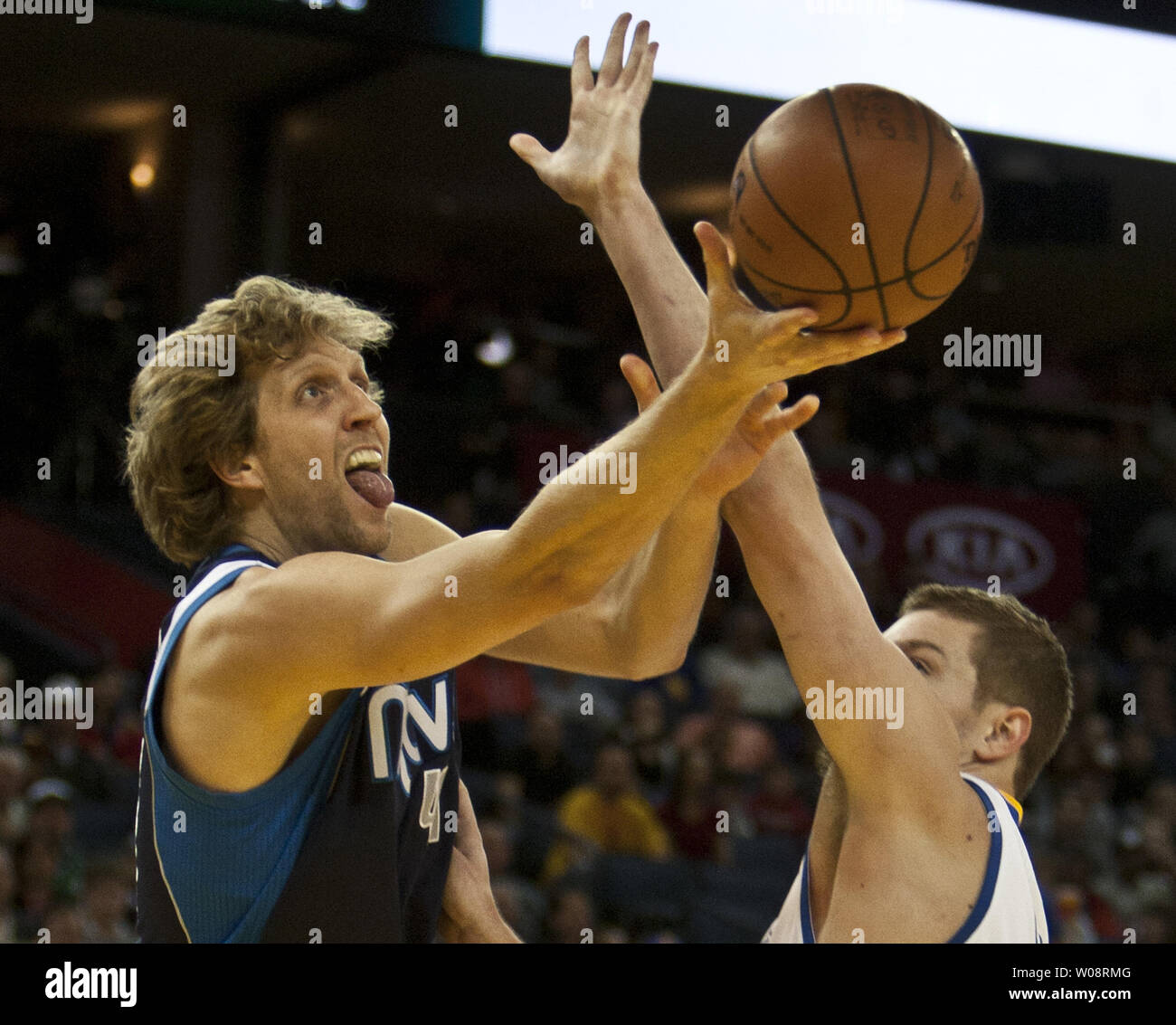 Portland Trail Blazers guard Raymond Felton (5) lays the ball up as he is  pressured by Dallas Mavericks forward Dirk Nowitzki (41), of Germany,  during overtime of an NBA basketball game on