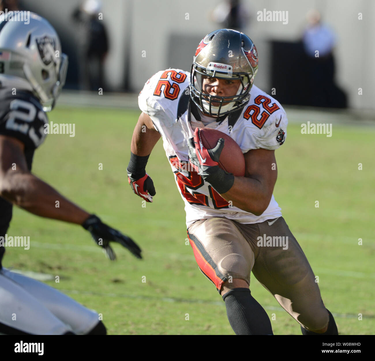 Tampa Bay Buccaneers RB Doug Martin (22) runs against Oakland Raiders Joselio Hanson (23) at O.co Coliseum in Oakland, California on November 4, 2012. Martin was a one man wrecking crew amassing 251yards and four TD's in the Bucs 42-32 victory.   UPI/Terry Schmitt Stock Photo